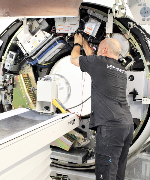 Open refurbished CT scanner with technician testing